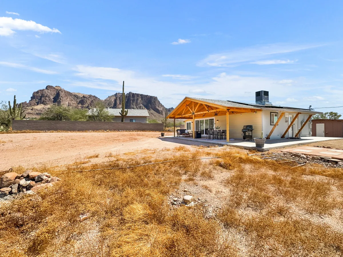 The image shows the bungalow’s inviting exterior with a picturesque mountain backdrop, a welcoming patio area, and surrounding cacti. The patio looks perfect for quiet mornings with coffee or evening gatherings under the stars, embodying the sense of peace and privacy described in the section.