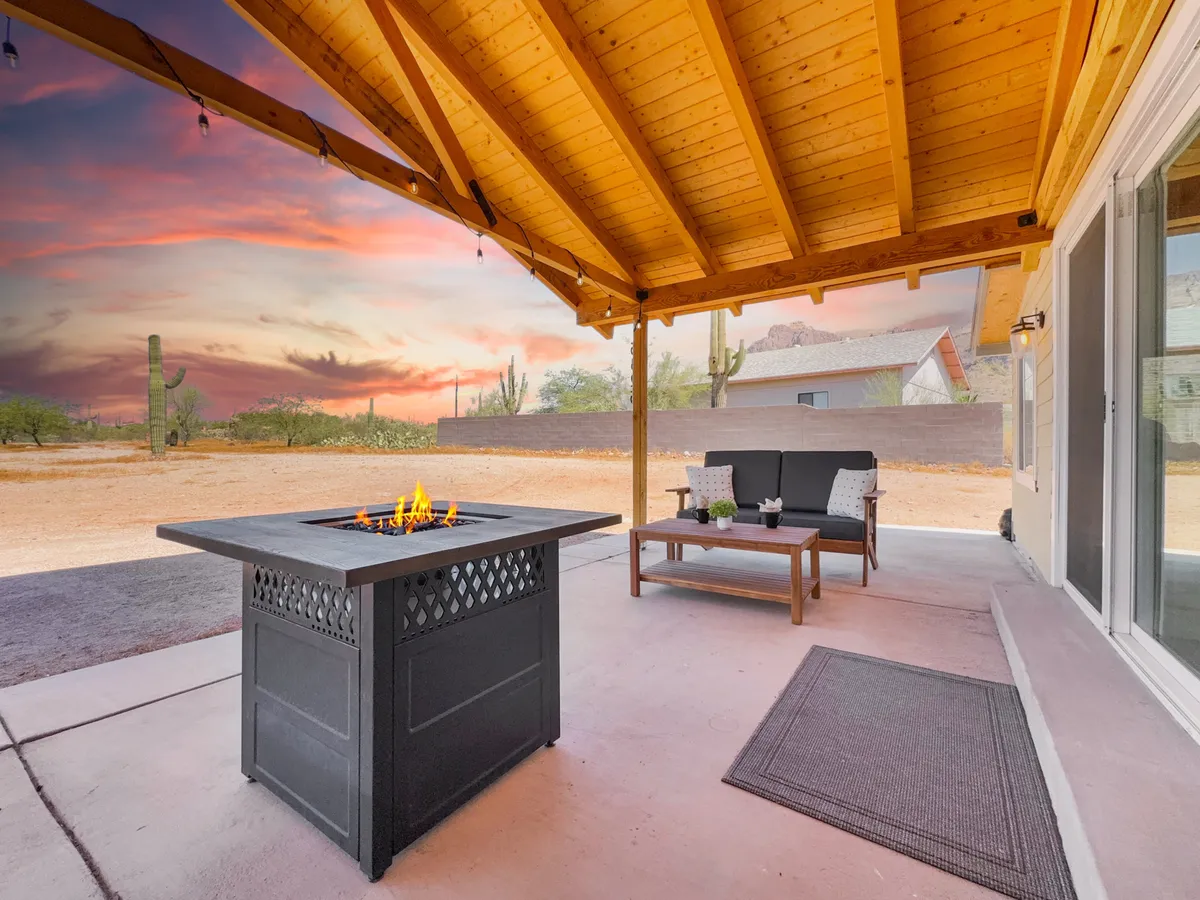 An outdoor fire pit area with comfortable seating, set against a glowing sunset sky. The arrangement invites gatherings for warmth, storytelling, and marshmallow toasting as daylight fades.